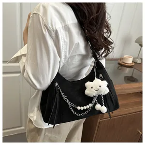 Detail of black underarm bag featuring silver chains, pearls, and a plush cloud charm