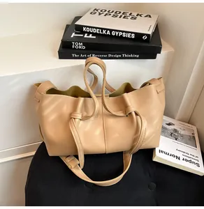 Gros plan du sac cabas beige en forme de chauve-souris avec ouverture plissée ondulée