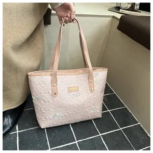 Detail view of pink quilted tote bag with colorful sequined bows and metal rivet handle