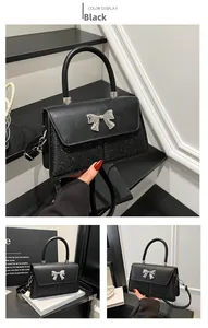 Detail of a black crossbody bag featuring a sequin base and silver metallic bow ornament
