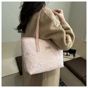 Pink quilted tote bag with sequin bow detail shown on shoulder in cozy room setting