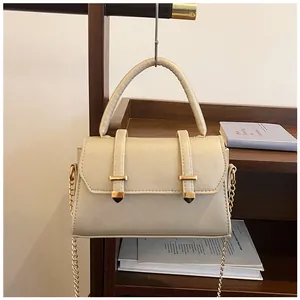 Detail of a beige cross-grain leather handbag with elegant golden T-shaped hardware