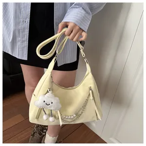 Detailaufnahme der zitronengelben Schultertasche mit dekorativer Perlenkette und Wolkenanhänger