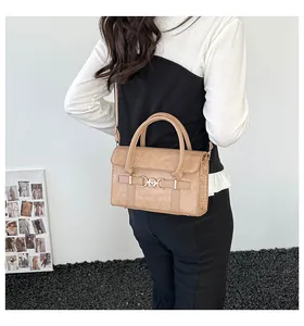 Detailed view of apricot crocodile texture handbag with adjustable strap on a model