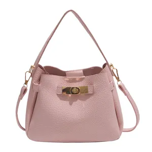 Minimalist pale pink bucket bag in lychee pattern leather with golden metal twist lock