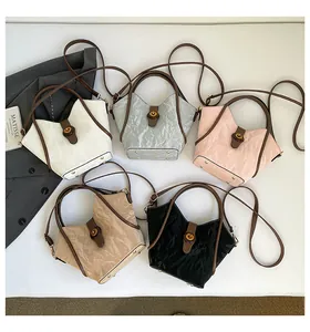 Top-down view of five pleated bucket bags in white, gray, pink, beige, and black