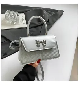 Detailed close-up of a silver bow buckle and sequined texture on a fashion handbag