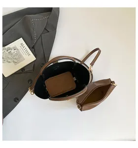 Top view of brown leather bucket bag with a detachable monogram pouch and shoulder strap