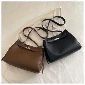 Detalle de los bolsos de cuero de lujo con cierre de giro metálico en negro y marrón