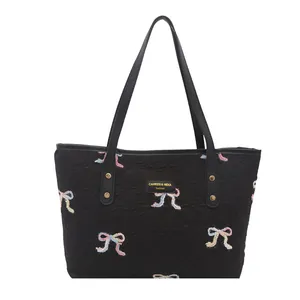 Chic black tote bag with colorful embroidered bows and sturdy dual shoulder handles