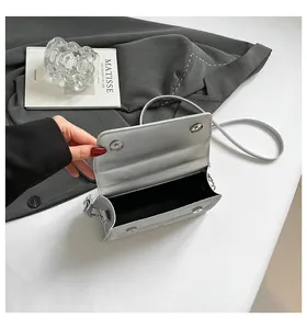 Detailed view of silver sequin bag with double magnetic snaps and black interior lining