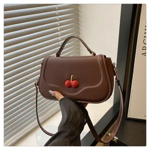 Sac bandoulière en cuir mat marron avec fermoir cerise rouge et poignée supérieure