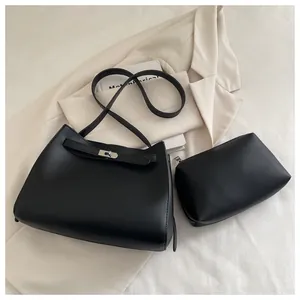 Detalle del conjunto de bolsos de cuero negro con cierre giratorio y bolso pequeño