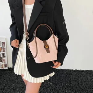 Pink and brown bucket bag with pleated texture and adjustable shoulder strap for women