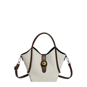 Chic two-tone cream and brown bucket bag with gold hardware and vintage round twist lock