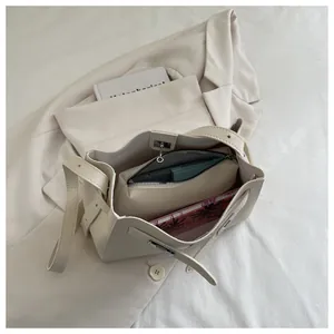 Detalle del bolso de cuero beige con neceser interior extraíble y correa ajustable