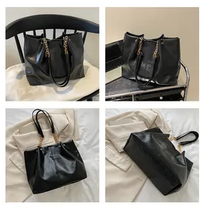 Detail view of large black leather tote bag with elegant gold chain and spacious interior