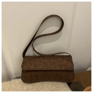 Brown leopard print baguette shoulder bag made of textured faux suede with flap closure