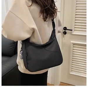Détail du grand sac cabas noir avec breloque en damier et bandoulière large