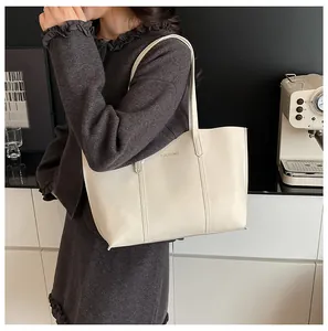 Model wearing a minimalist cream leather tote bag for daily commute and urban style
