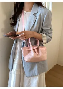 Pink woven texture bucket bag shown on a model highlighting size and crossbody style