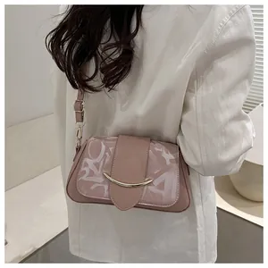 Detail der rosa Satteltasche mit weißen Mustern und goldener Schnalle am Modell getragen