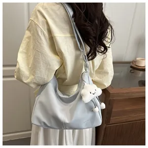Close-up of light blue PU leather tote bag featuring a cute white cloud plush charm