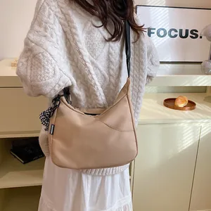 Sac croissant kaki avec bandoulière réglable dans un décor intérieur douillet