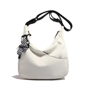 Sac fourre-tout croissant en nylon beige minimaliste avec sangle noire et breloque