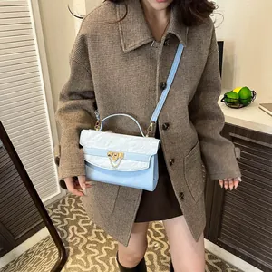 Sac à bandoulière bleu et blanc avec gaufrage nuage et chaîne dorée sur mannequin