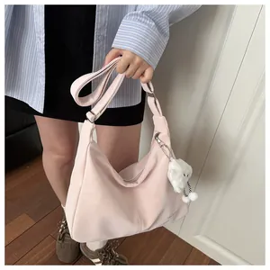Detail of light pink crescent bag with adjustable strap and plush cloud charm