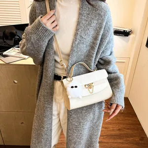 Sac bandoulière carré en cuir beige chic avec fermoir métallique et breloque peluche