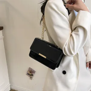 Stylish black patent leather crossbody bag with gold chain strap and metal clasp for women