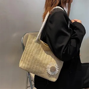 Chic woven straw tote bag with daisy ornament and rope handle shown on a model