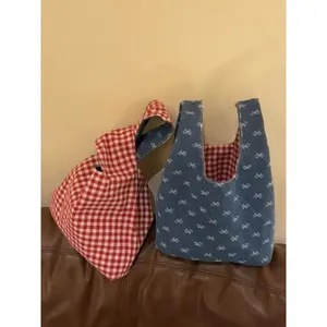Tragetasche mit rotem Karomuster und weißer Schleifenstickerei auf marineblauem Stoff