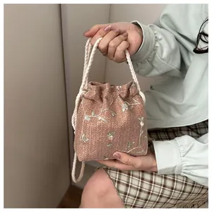 Detailansicht der rosa geflochtenen Beuteltasche mit Blumenstickerei und Baumwollkordel
