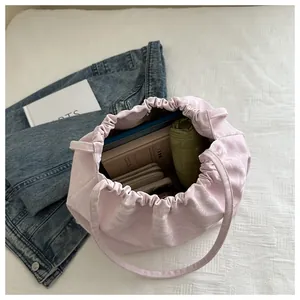 Pink drawstring bucket bag showing spacious interior with books and umbrella