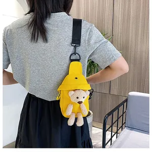 Detail of yellow canvas chest bag featuring a cute 3D plush bear on the front side