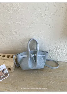 Detail of light blue woven PU leather bucket bag with handle and slim shoulder strap