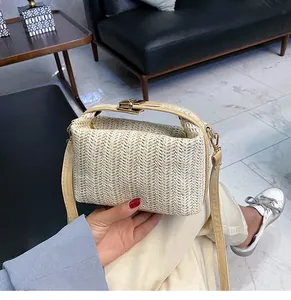 Macro detail of straw woven handbag with V-shaped texture and golden metal lock