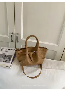 Close-up of caramel woven bucket bag with smooth leather handle and shoulder strap detail