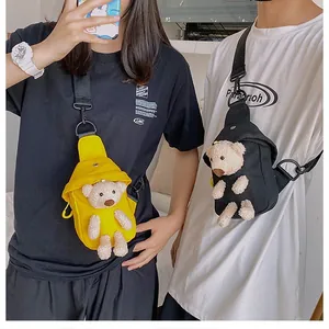 Detail view of canvas crossbody bags featuring cute 3D plush bear charms in yellow and black