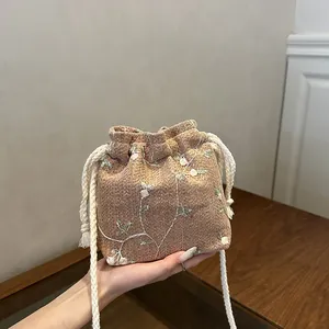 Minimalistische gewebte Beuteltasche mit Blumenstickerei und weißem Kordelzug