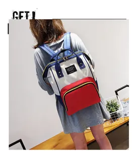 Detail view of stylish tri-color patchwork diaper backpack with top handles and logo patch