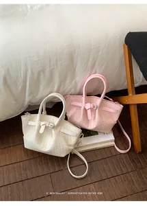 Detail of woven texture and strap buckle on white and pink bucket crossbody bags