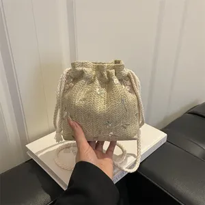 Beigefarbene gewebte Eimertasche mit rosa Blumenstickerei und Fransenriemen
