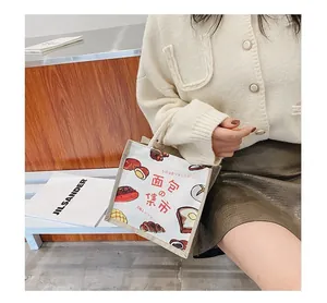 Detail of canvas tote bag featuring bread illustrations and thick rope handle style