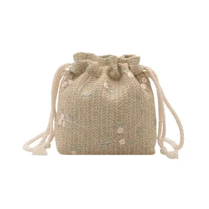 Minimalistische gewebte Beuteltasche mit Blumenstickerei und Kordelzug auf weißem Grund