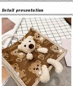 Macro view of canvas tote bag featuring 3D plush bear and white braided rope handles