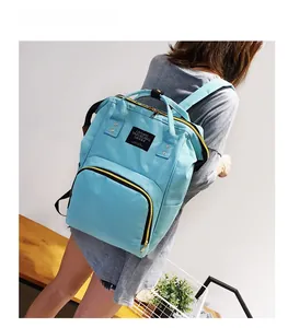 Detail showing the large fish-mouth opening and front pocket of the light blue diaper backpack